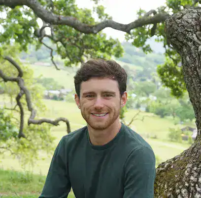 Young man outdoors with nature background, promoting awareness of eating disorders and resources.