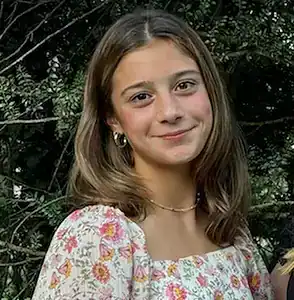 Young girl smiling outdoors, promoting understanding and support for eating disorder recovery.