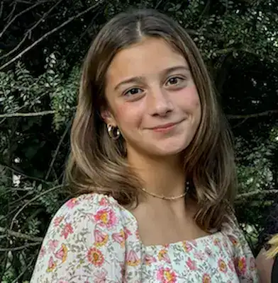 Young girl smiling outdoors, promoting understanding and support for eating disorder recovery.