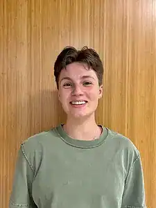 Young woman smiling, promoting awareness of eating disorders and mental health support.