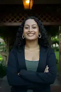 Diverse woman smiling outdoors, advocating for eating disorder awareness and support.