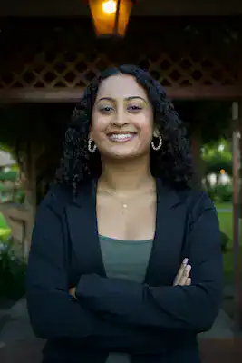 Diverse woman smiling outdoors, advocating for eating disorder awareness and support.