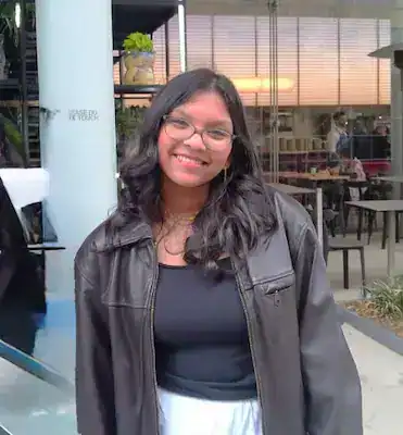 Young woman smiling at a cafe promoting eating disorder awareness and recovery.